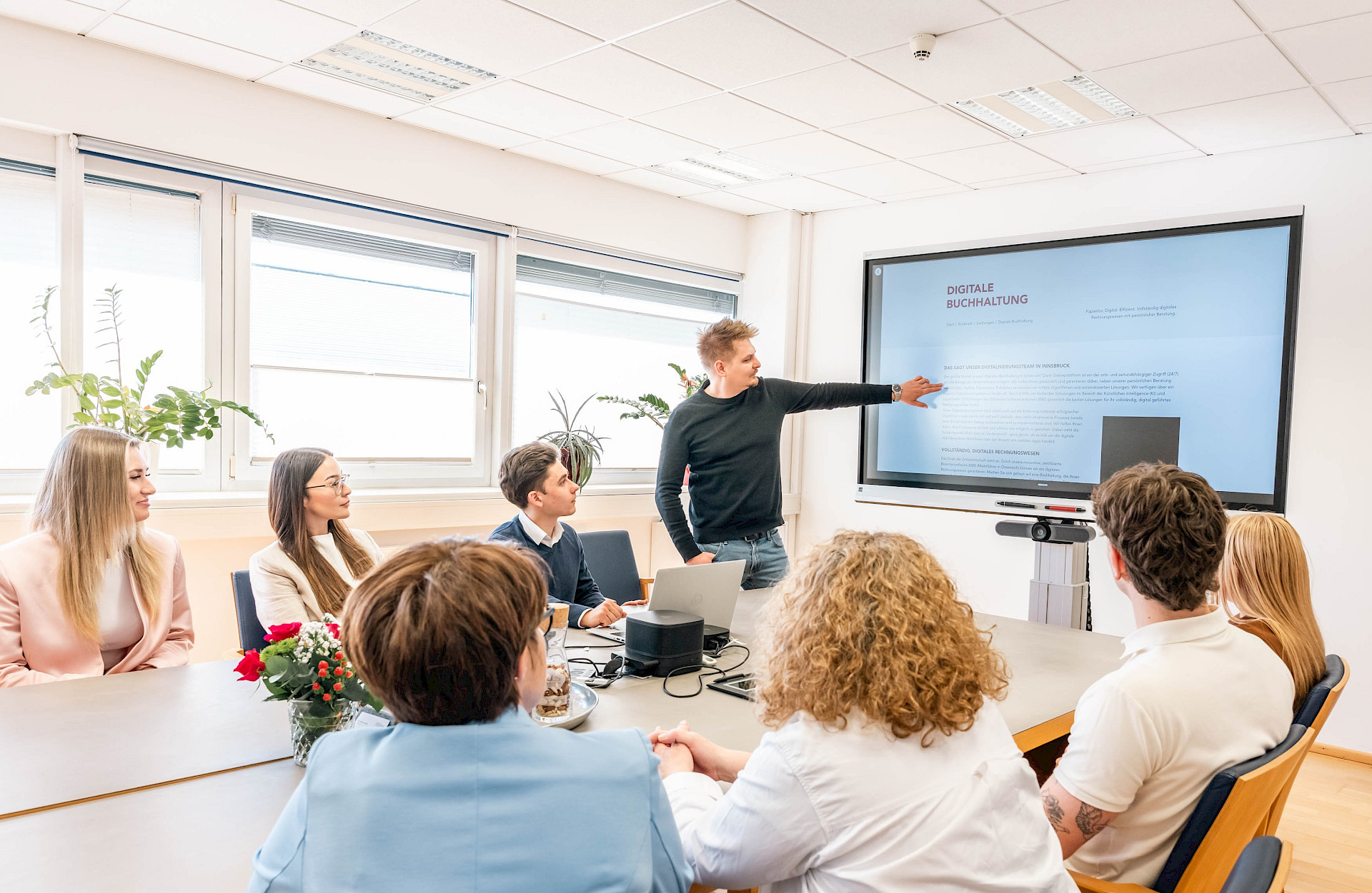 Eine Gruppe von verschiedenen Mitarbeitern spricht über digitale Buchhaltung in Innsbruck